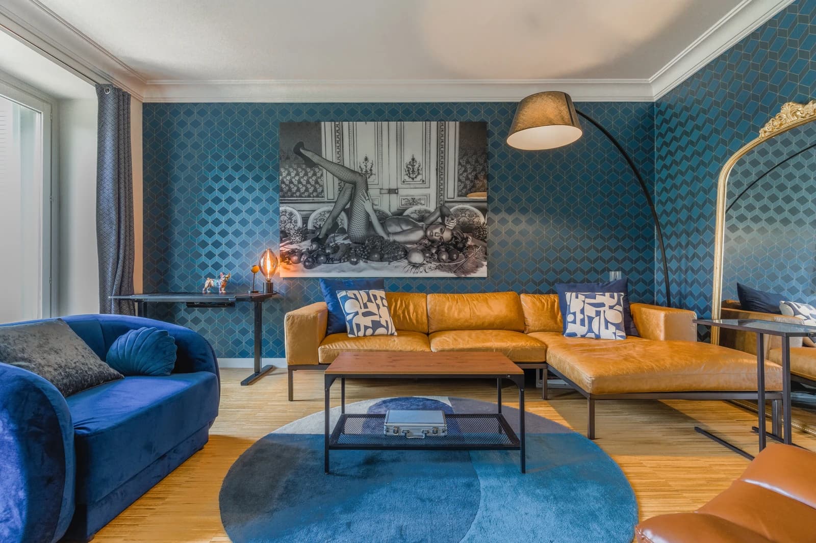Bold blue patterned lounge with leather sectional and mirrored archway