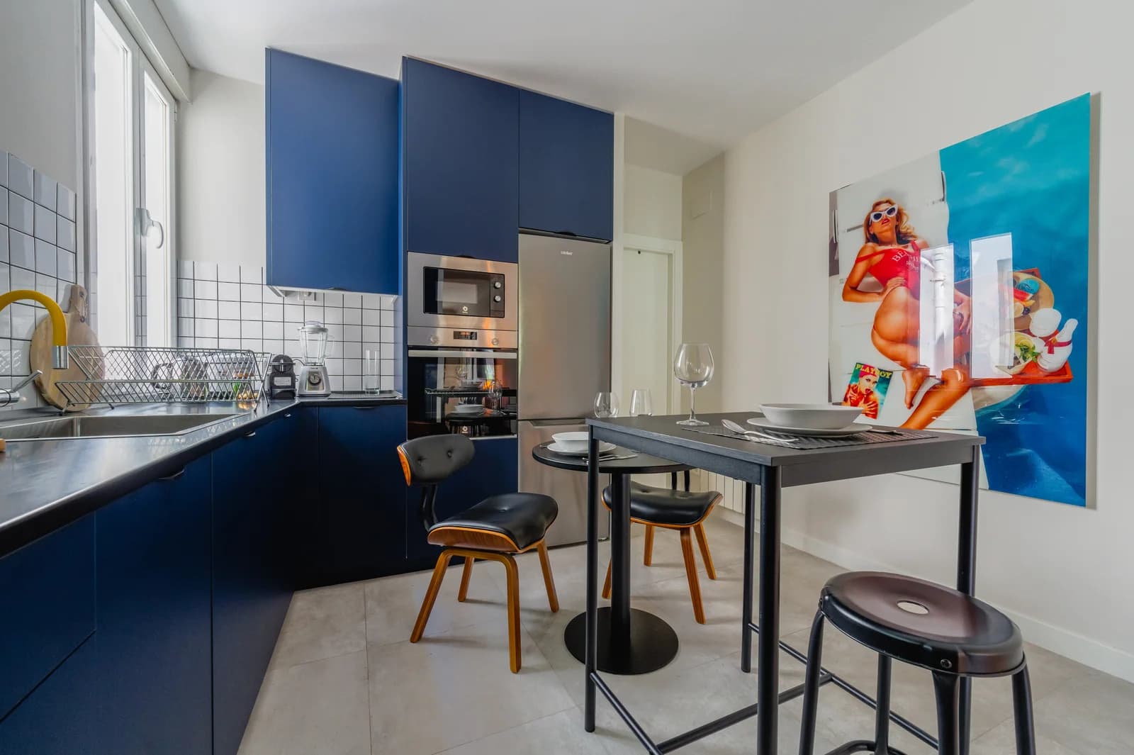 Navy blue kitchen with bar table, white tile and pop-art accent