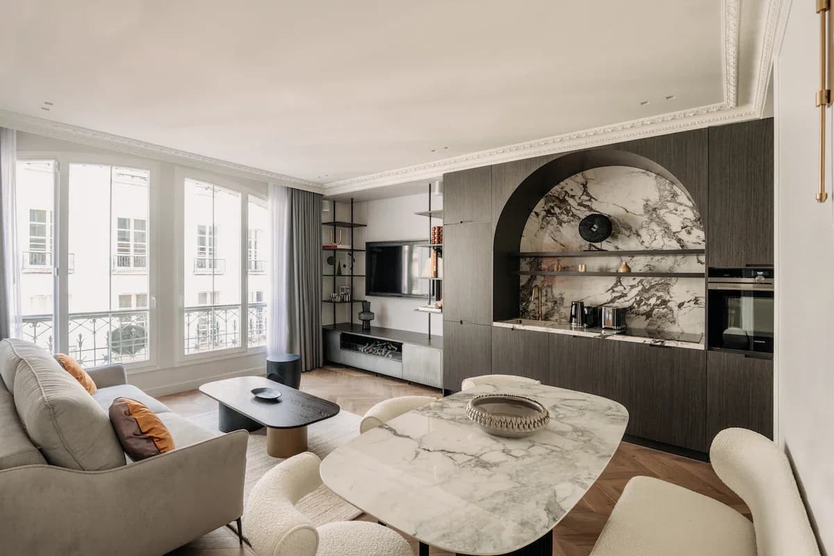 Open Haussmannian living-dining with arched marble kitchen niche and Paris balcony