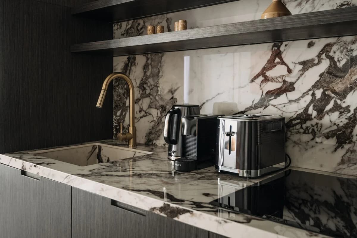 Brass tap and dramatic marble splashback with brewing essentials