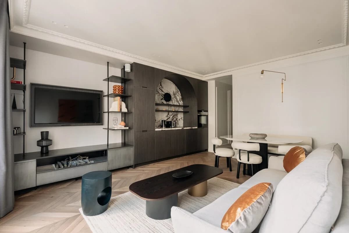 Sculptural lounge with curved sofa, walnut wall, marble dining nook
