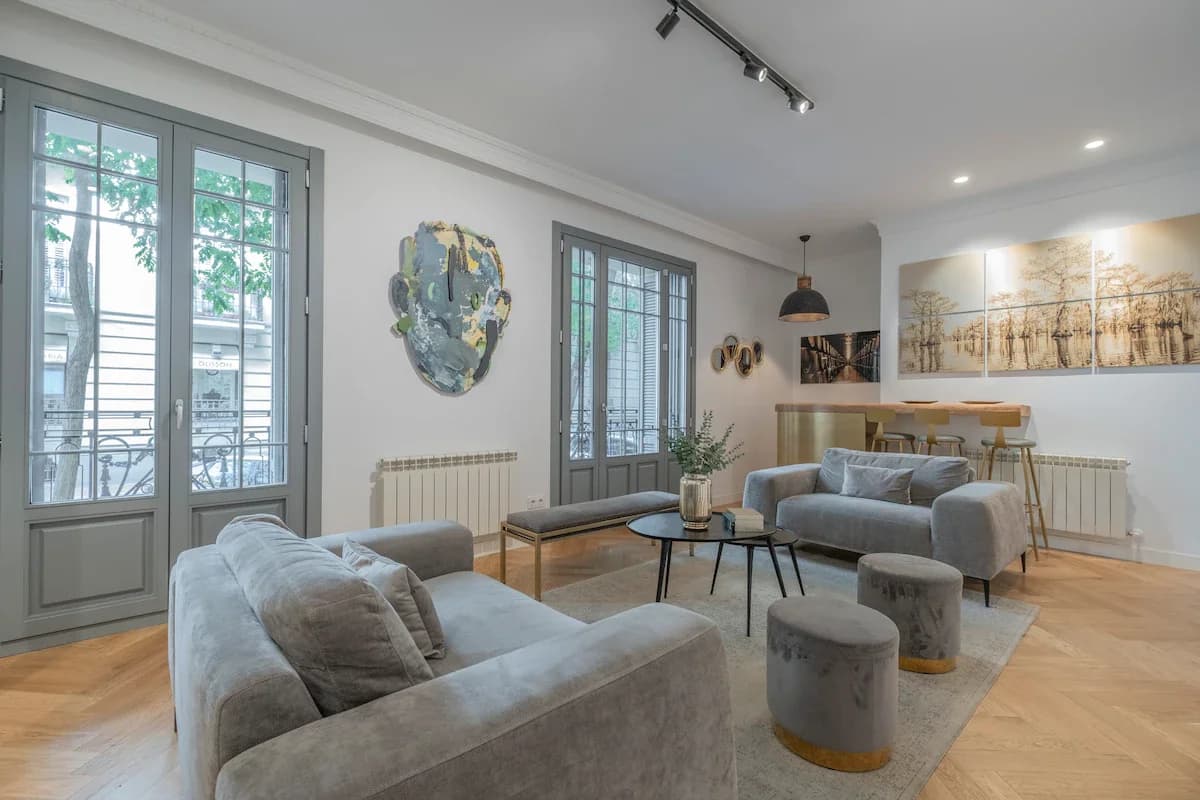 Bright living room with French balconies, velvet sofas and gold-toned art