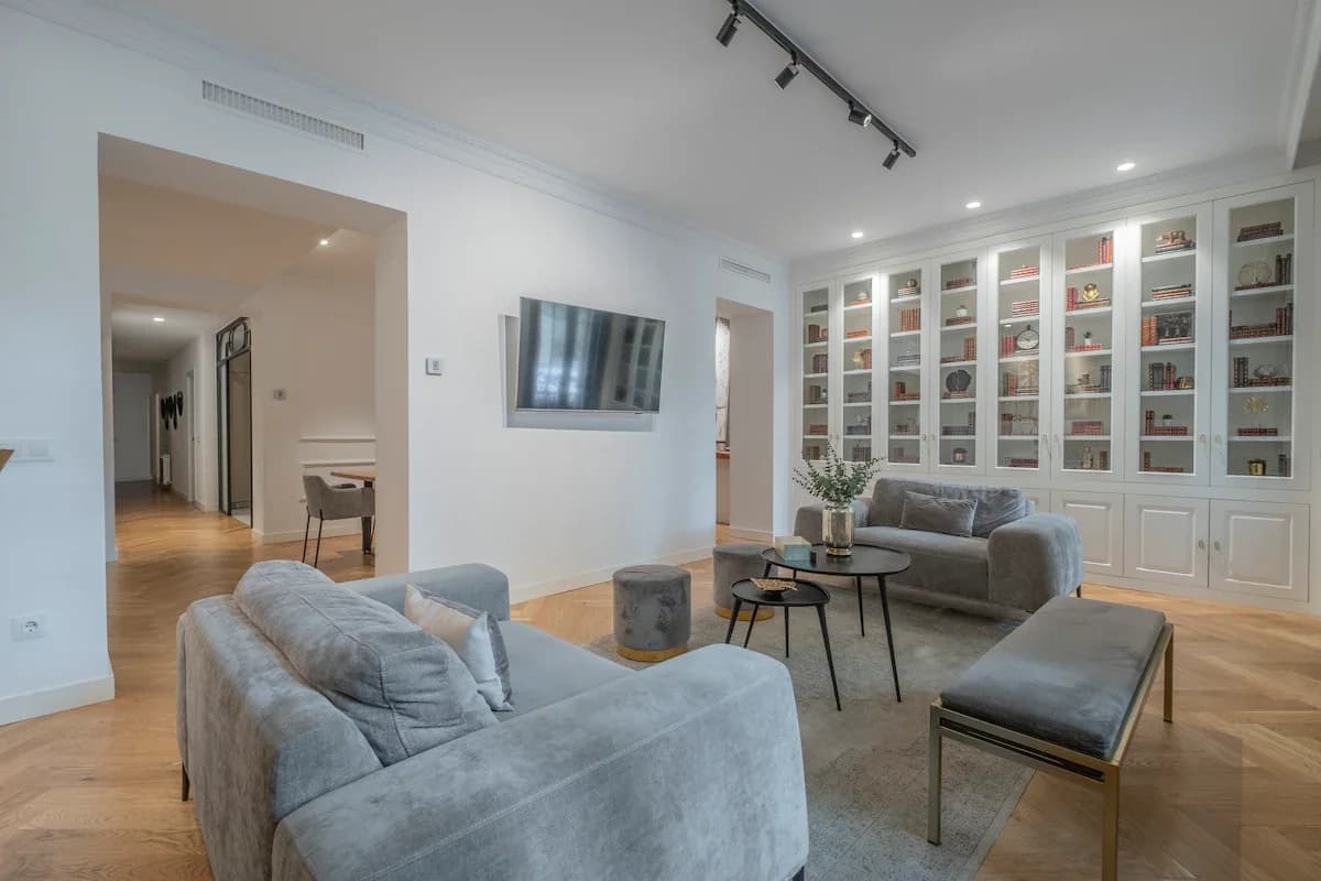 Open plan with two sofas, library and herringbone parquet