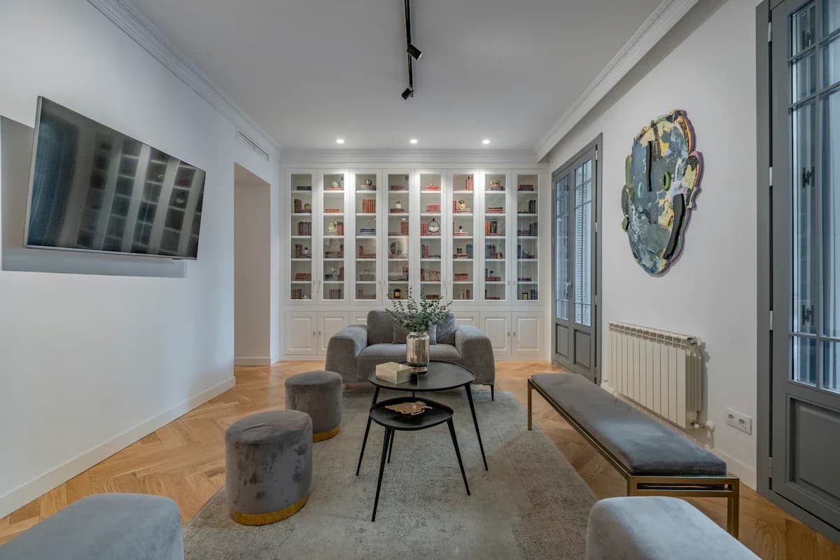 Symmetrical seating with bookcase, art and elegant balcony doors