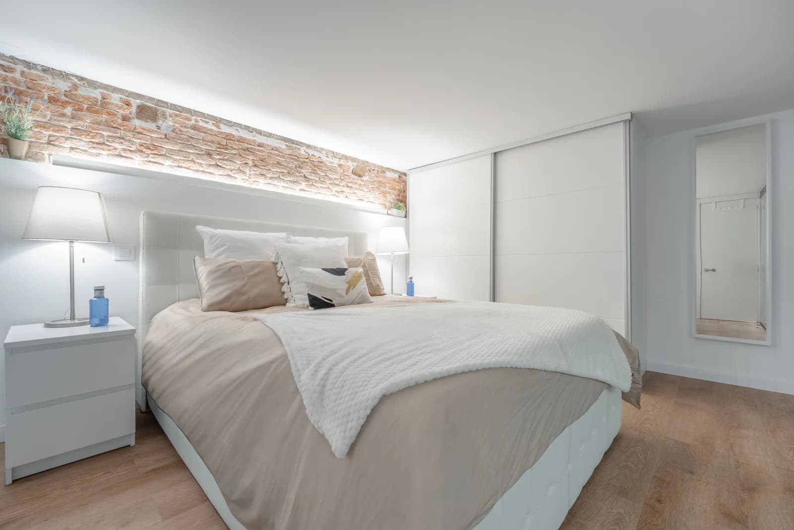 Bright loft bedroom with brick accent above the bed
