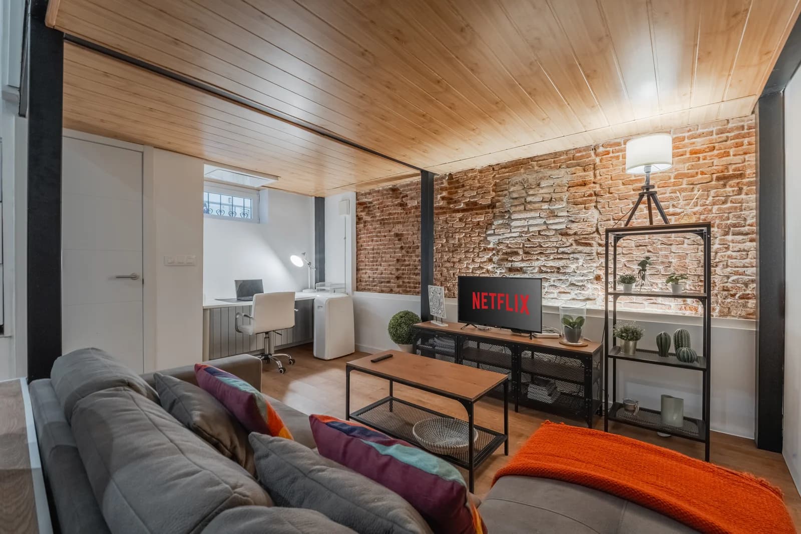 Industrial loft lounge with brick wall, wood ceiling and ivy-clad backdrop