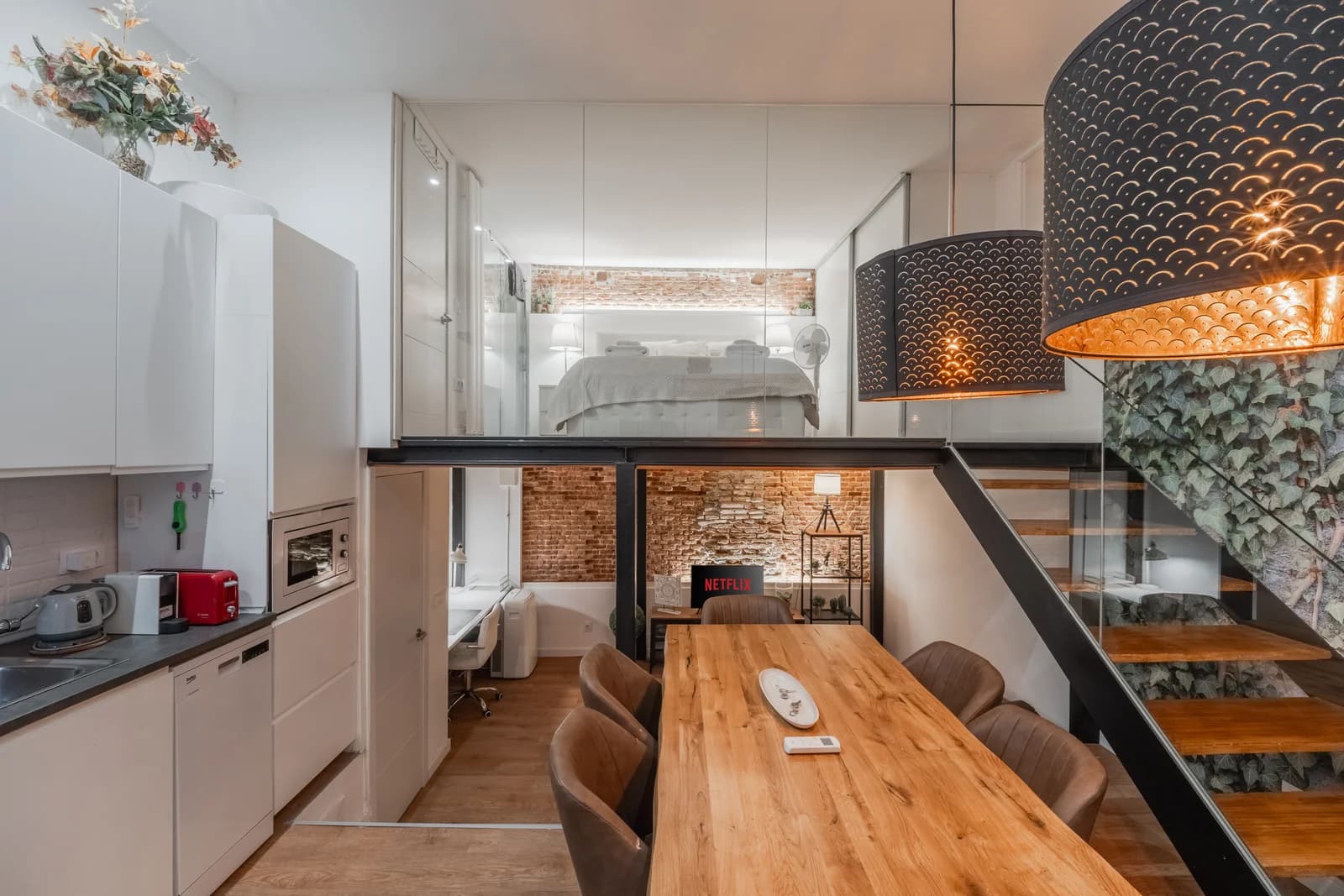 Mezzanine view with kitchen, ivy wall and exposed brick beyond