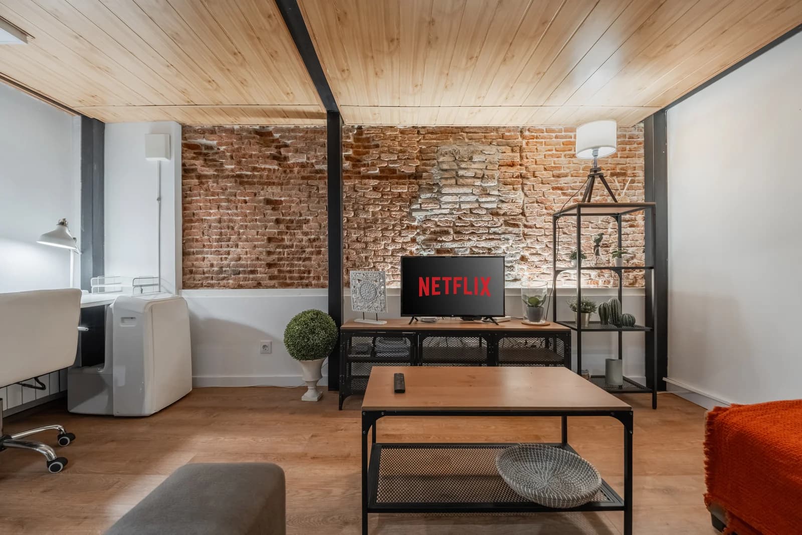 Lounge with exposed brick, wood ceiling and warm reading nook