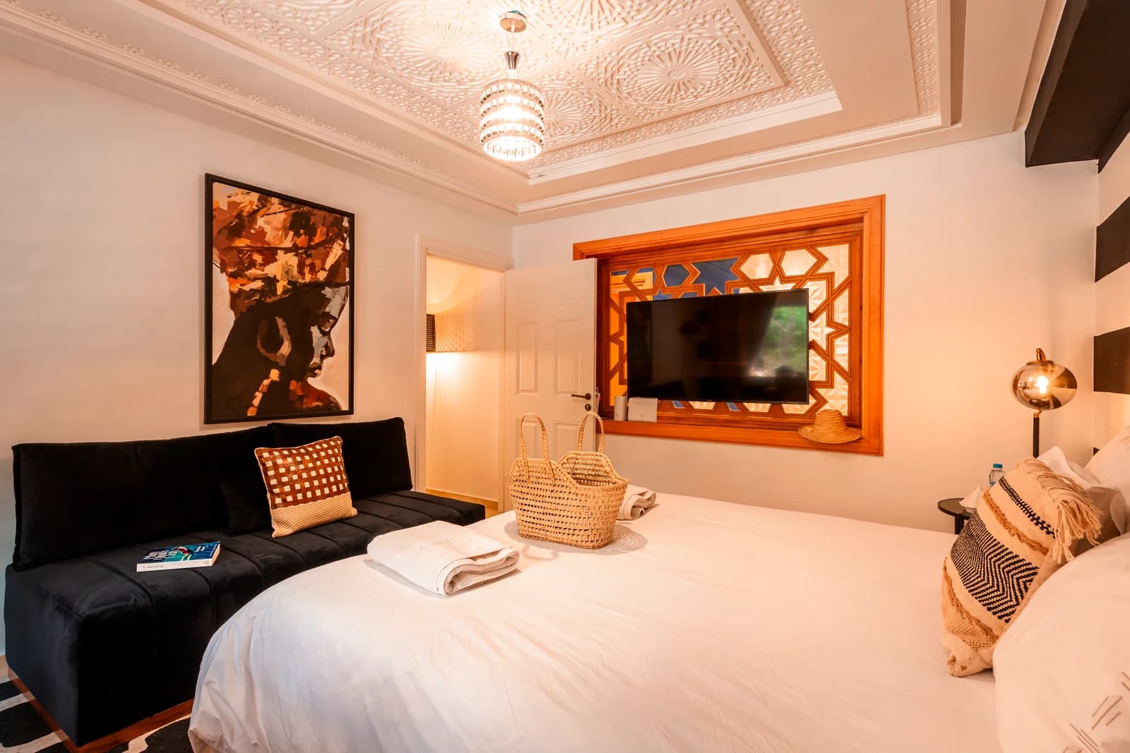 Moroccan zellige TV frame beneath richly carved plaster ceiling