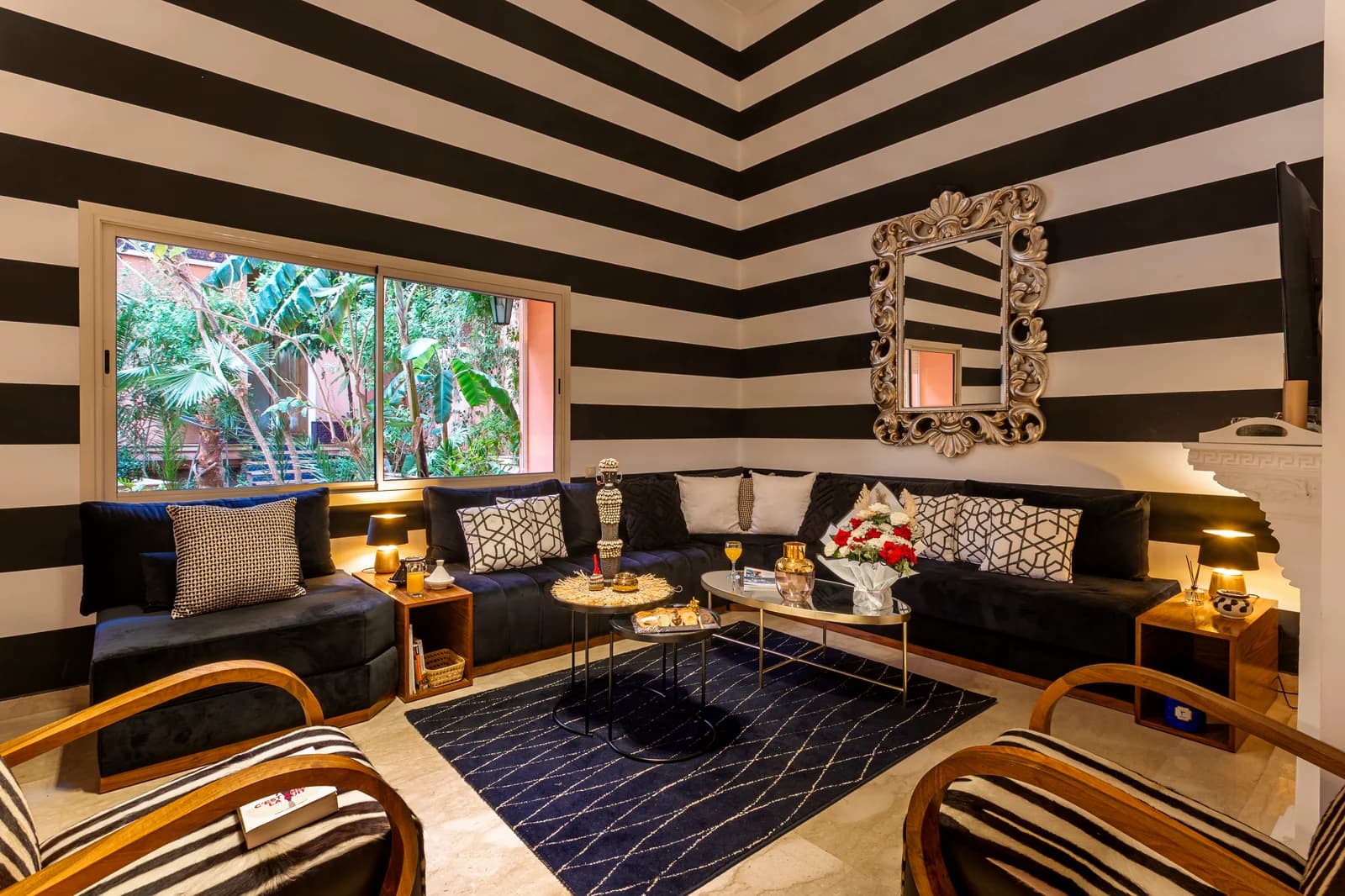 Banquette seating beneath black-and-white stripes with garden view
