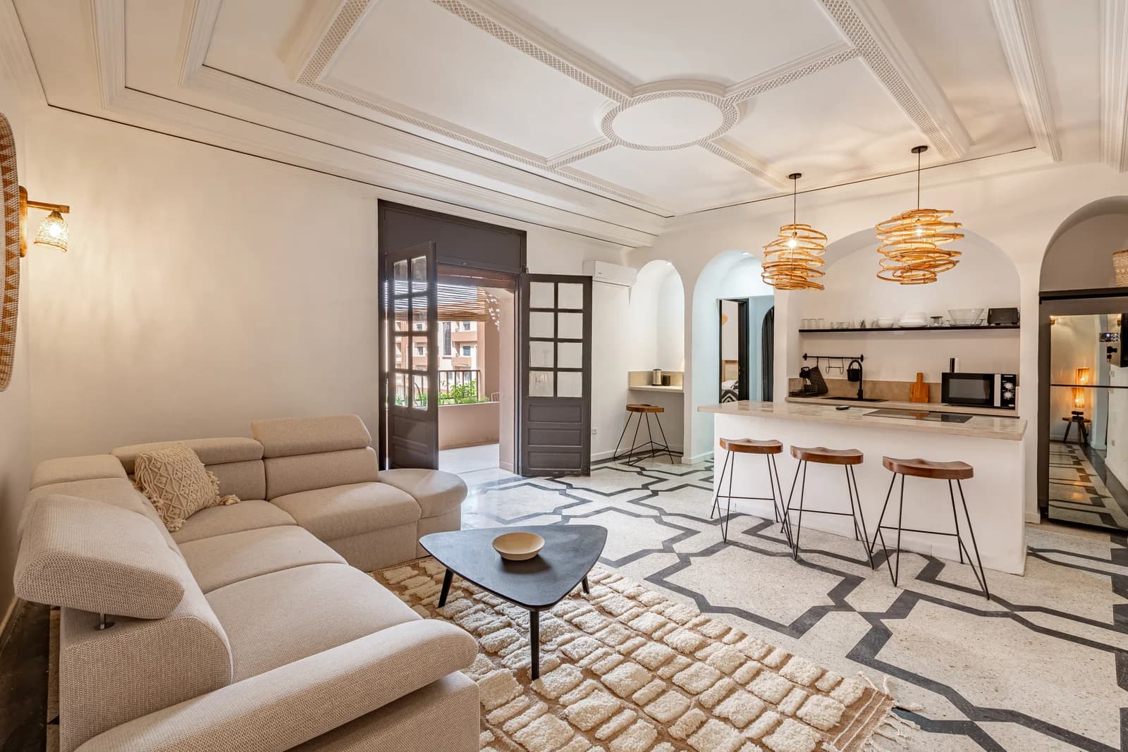 Bright open living-kitchen with patterned terrazzo floor and ornate ceiling