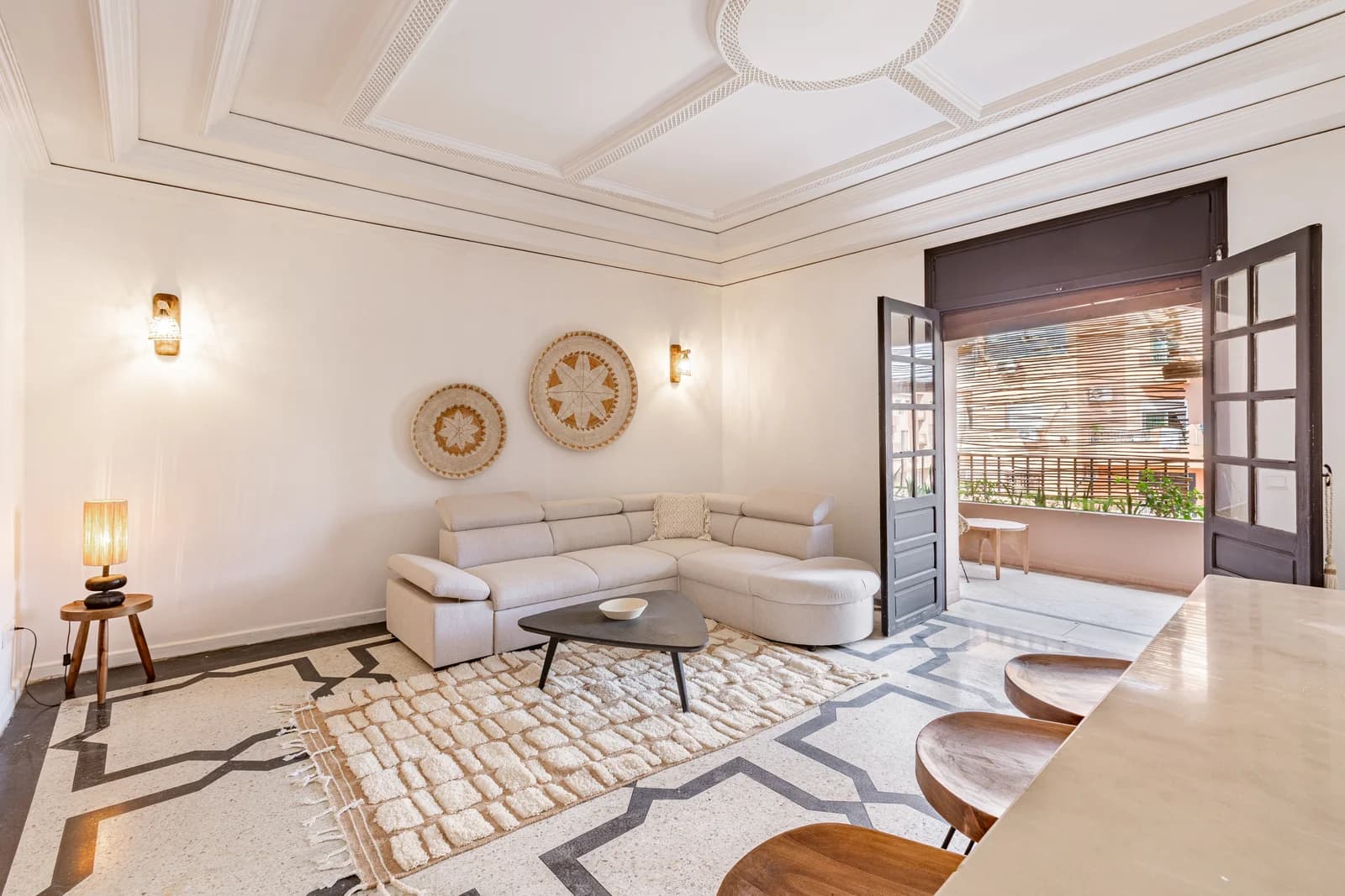 Cream sectional beneath coffered ceiling with wicker wall art